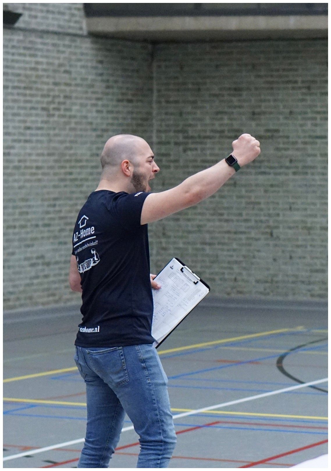 Coach Tijn Koenen juicht tijdens volleybalwedstrijd de Burgst Breda na het scoren van een punt