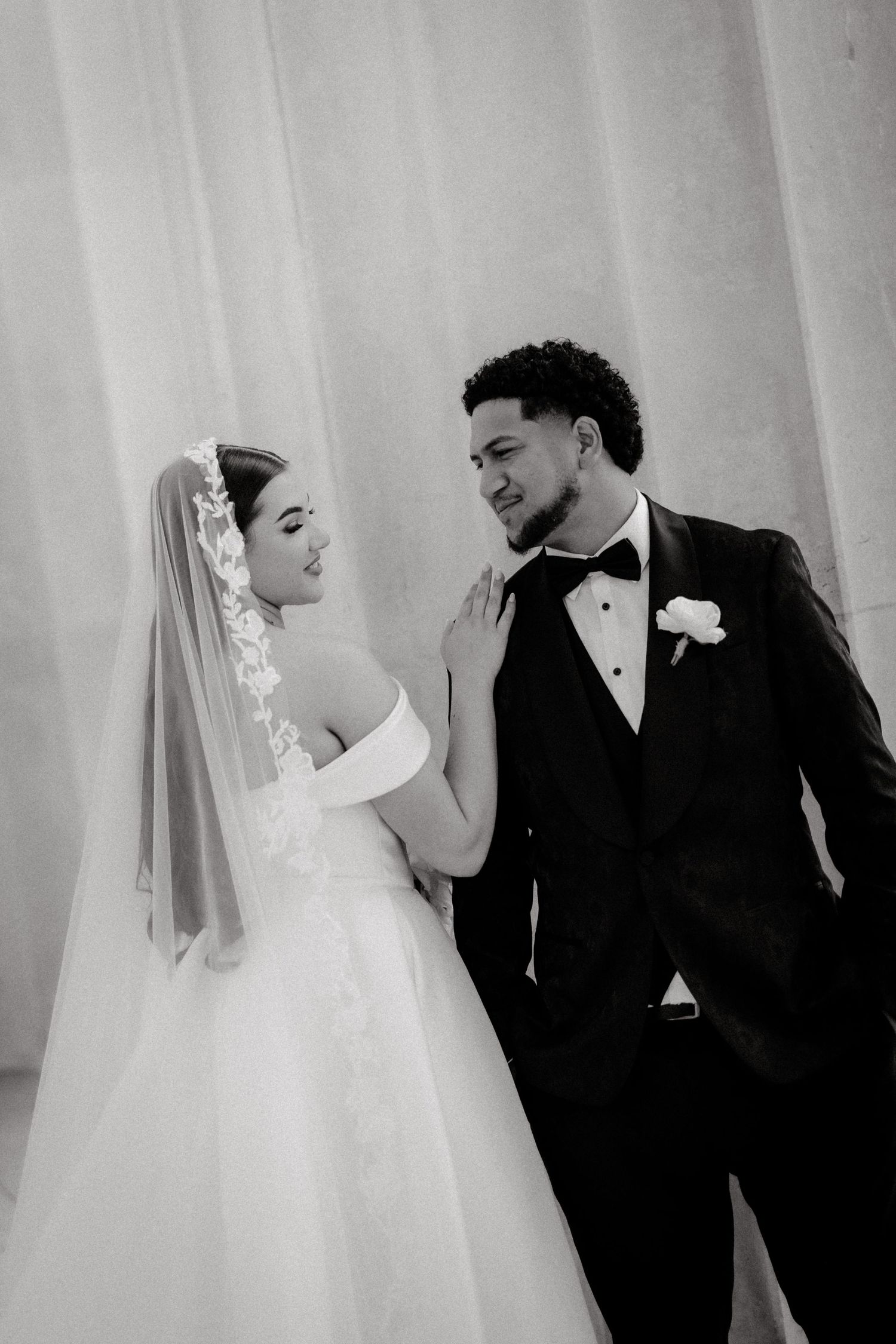 Four romantic black and white wedding photos showing a happy couple sharing intimate moments wearing traditional formal attire.