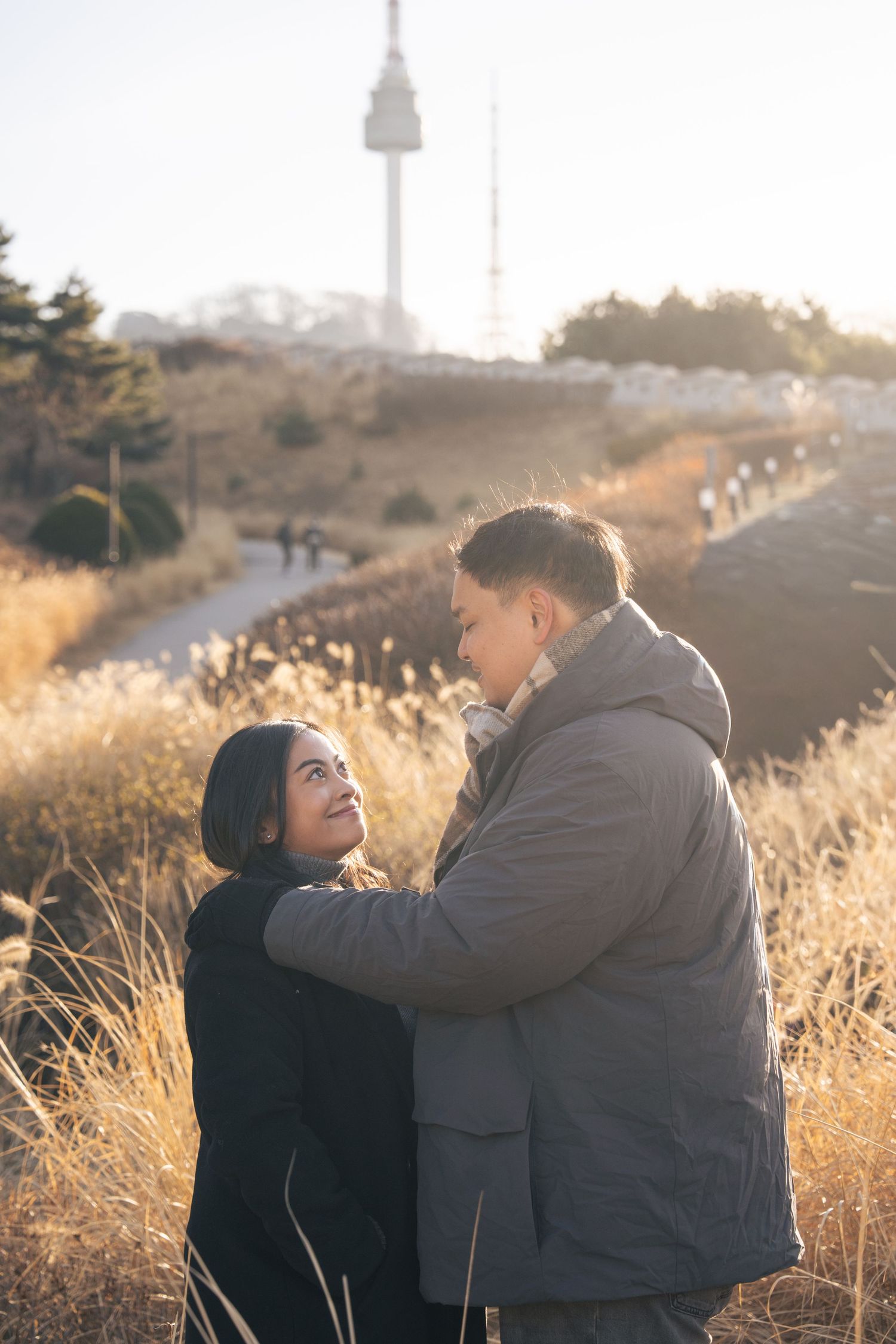 A couple shares a tender moment together in a golden field during sunset, captured in a sequence of romantic poses.
