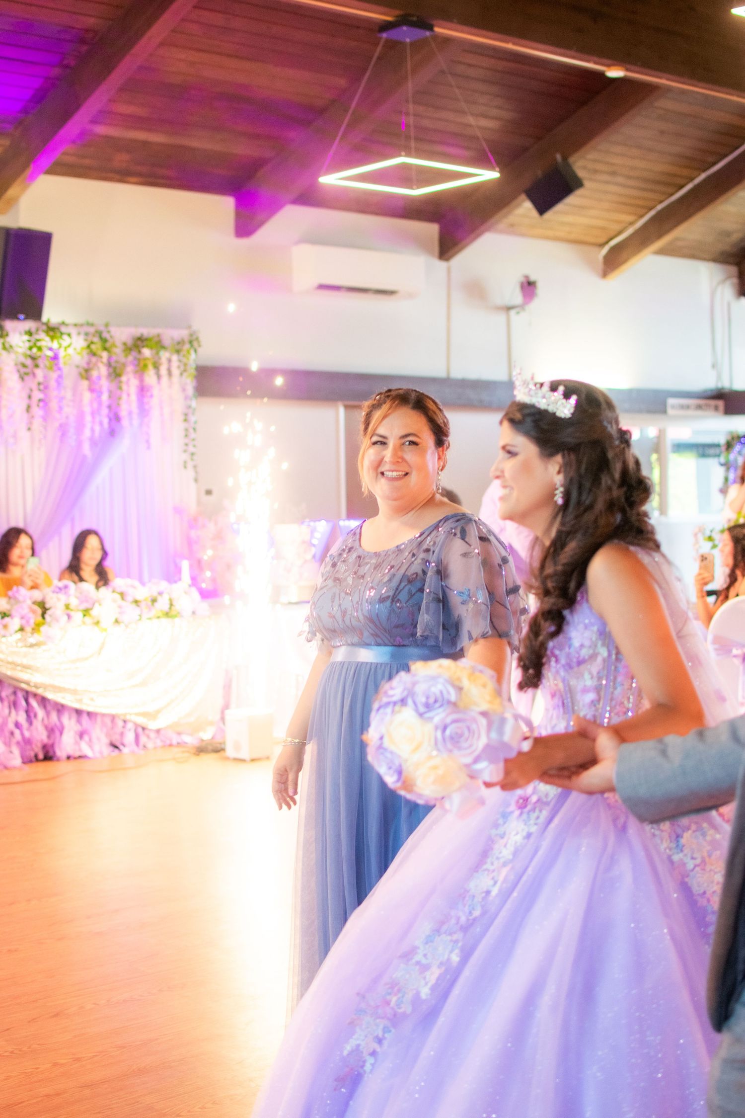 People dancing and celebrating at a wedding reception with sparklers creating a magical atmosphere.