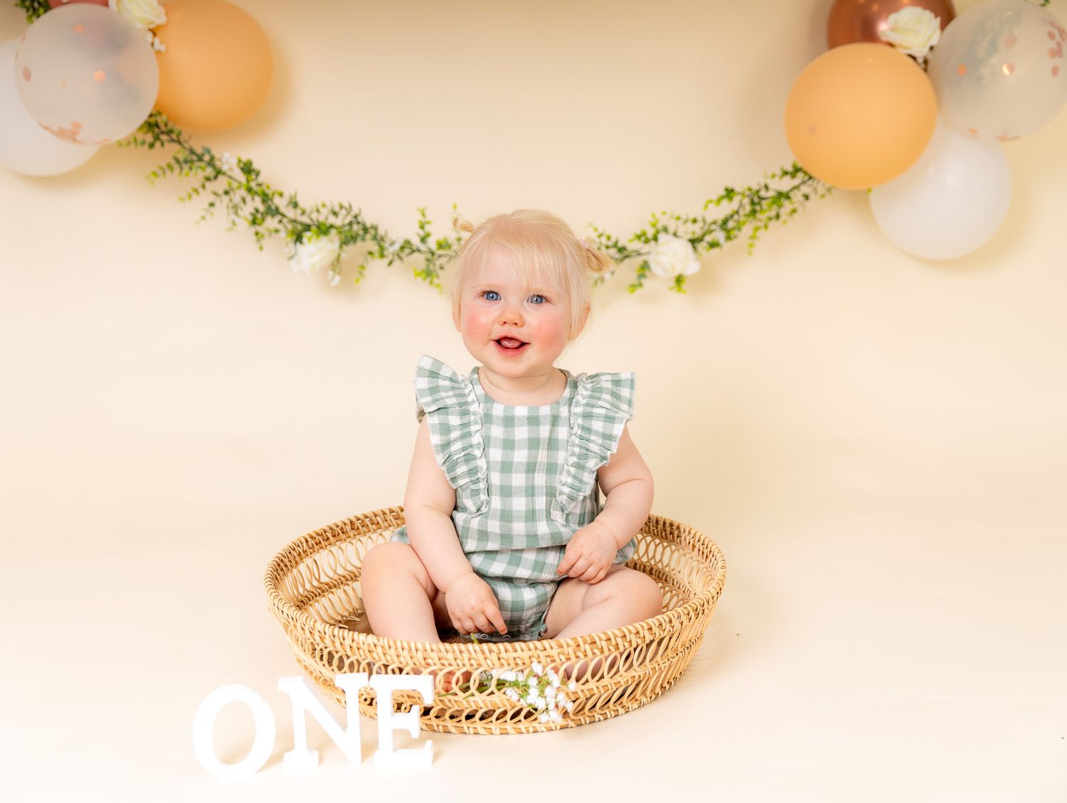 A rustic first birthday photo collage featuring wooden decorations, cake smash moments, and floral accents.