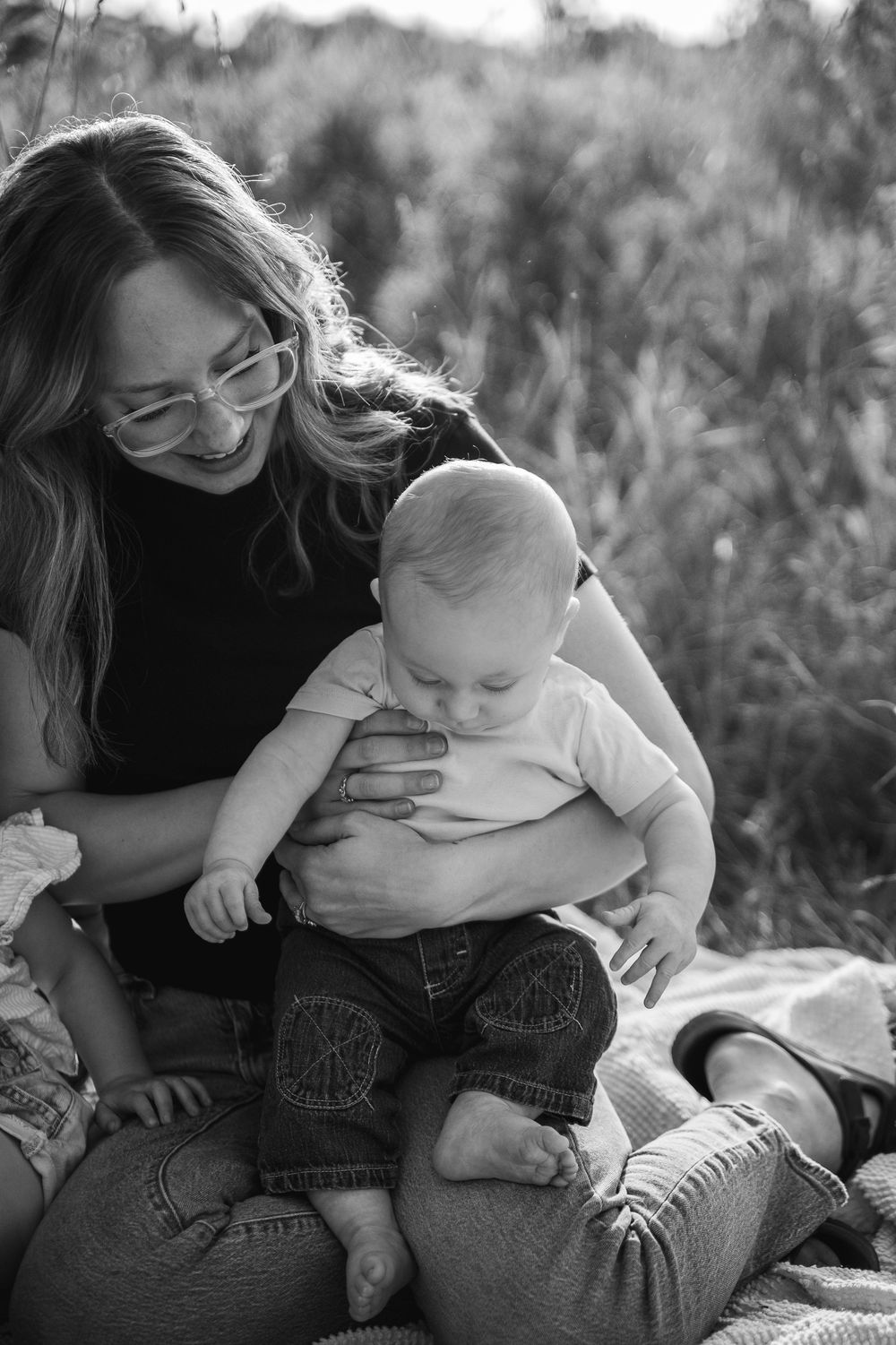 A tender black and white photo sequence showing a parent and child sharing loving embraces outdoors.