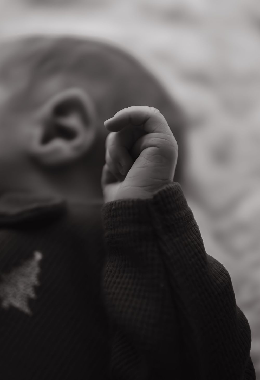 Series of black and white close-up shots showing small fingers and hands.