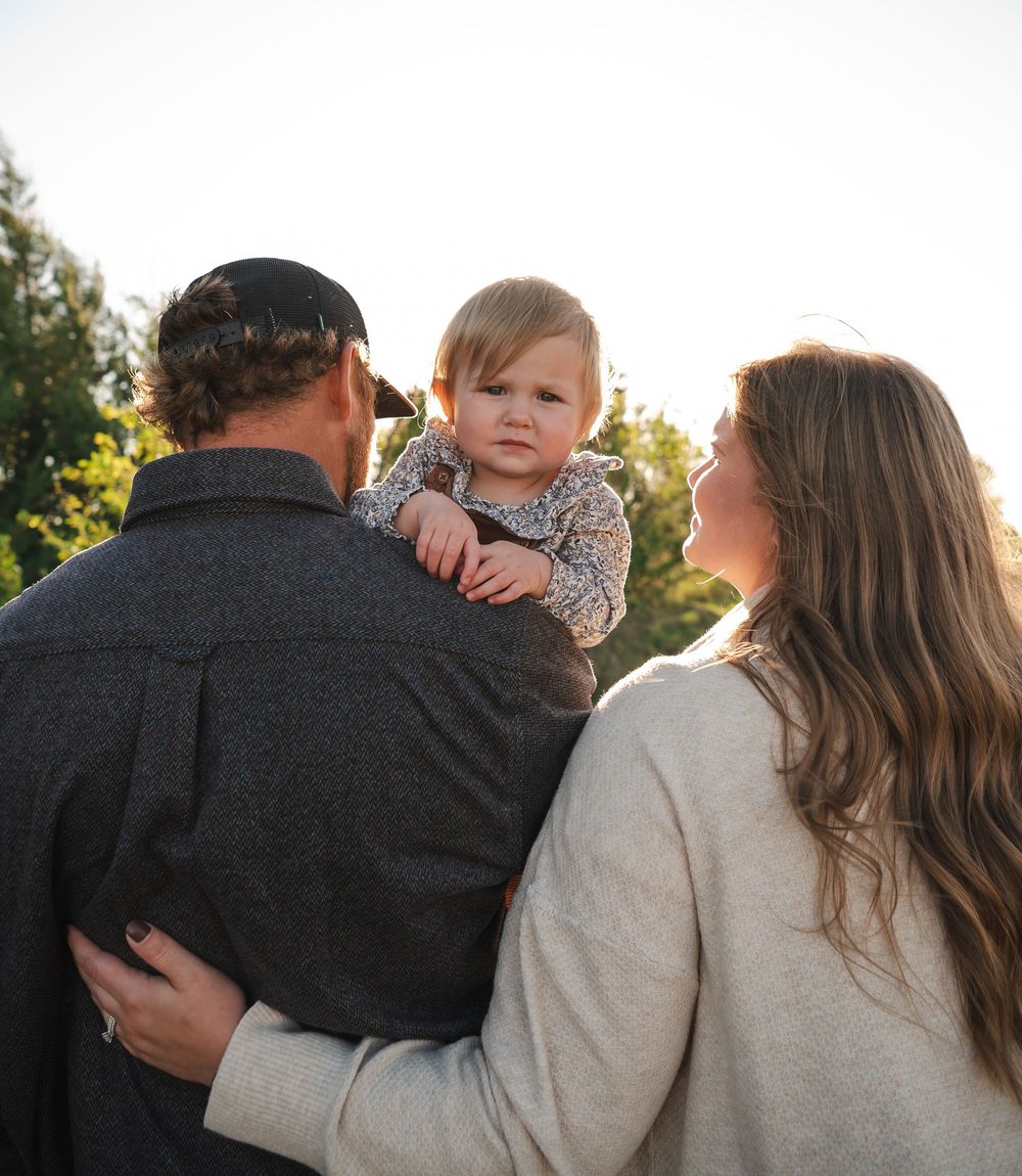 A family embracing together during golden hour in an outdoor setting.