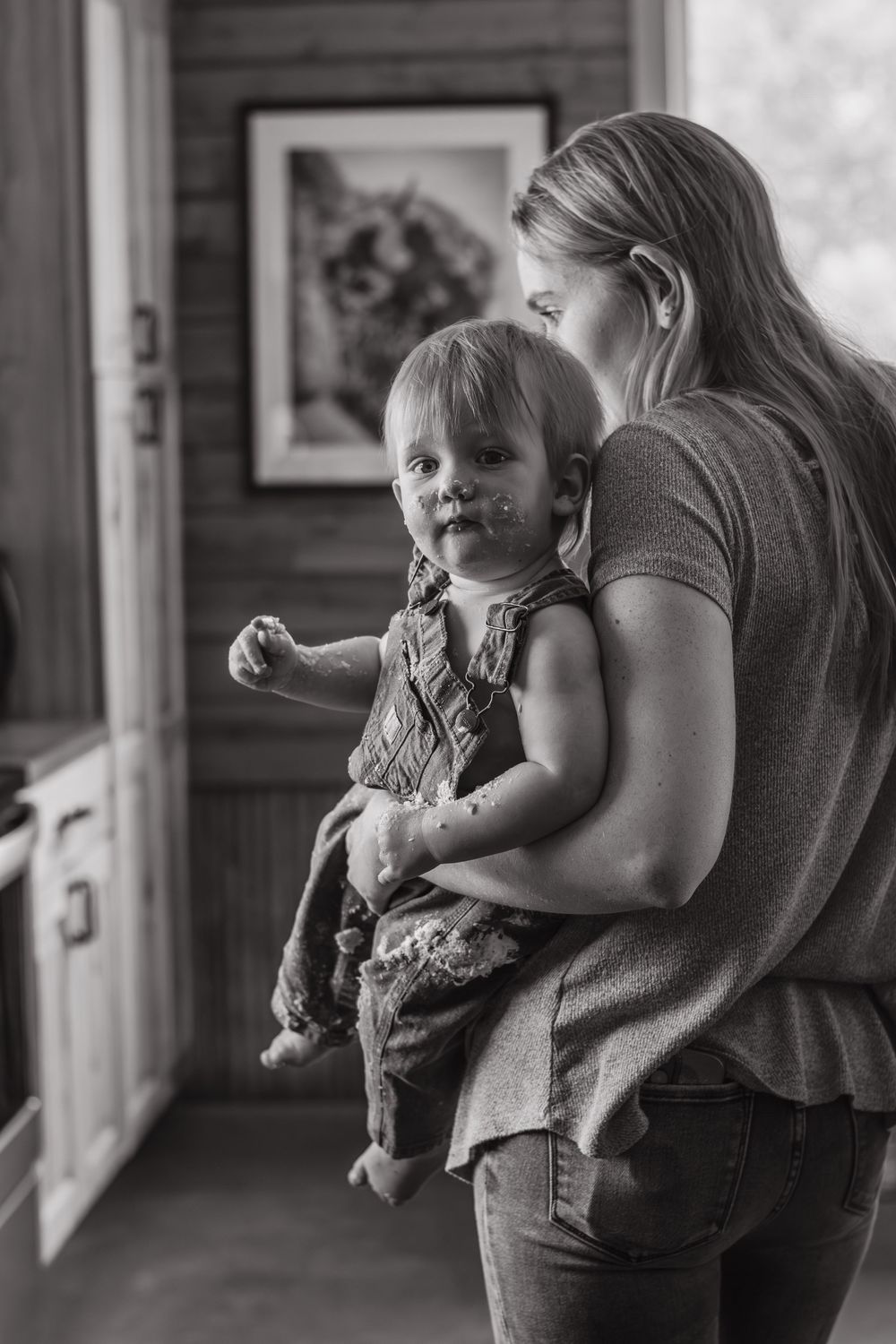 A tender moment captured in black and white as a child is held indoors.