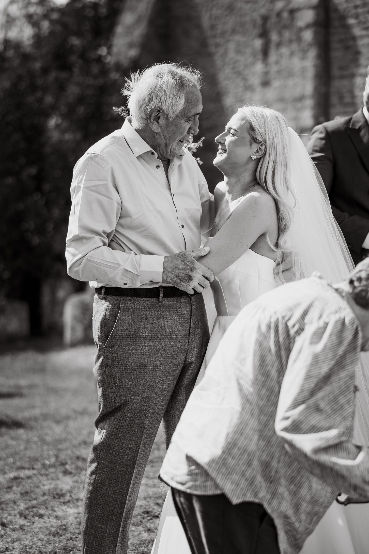 Black and white candid moments of joyful interaction at a wedding celebration.