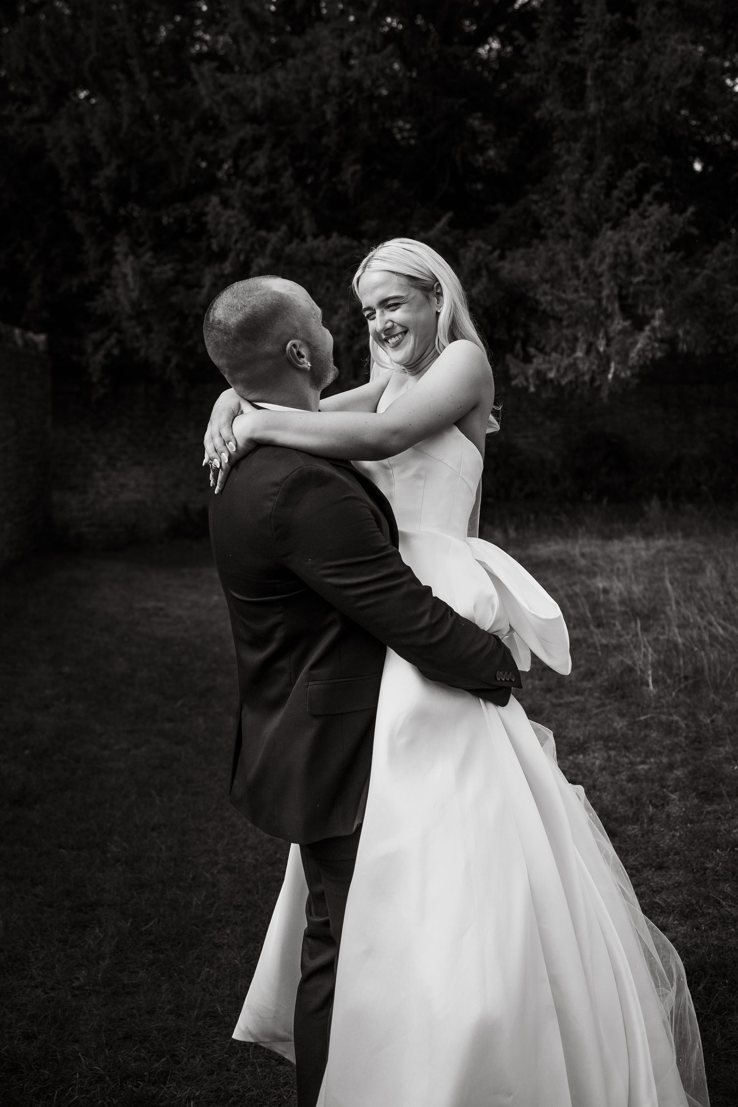 Black and white photo series showing a couple dancing together at a wedding, with the bride in a flowing white gown.