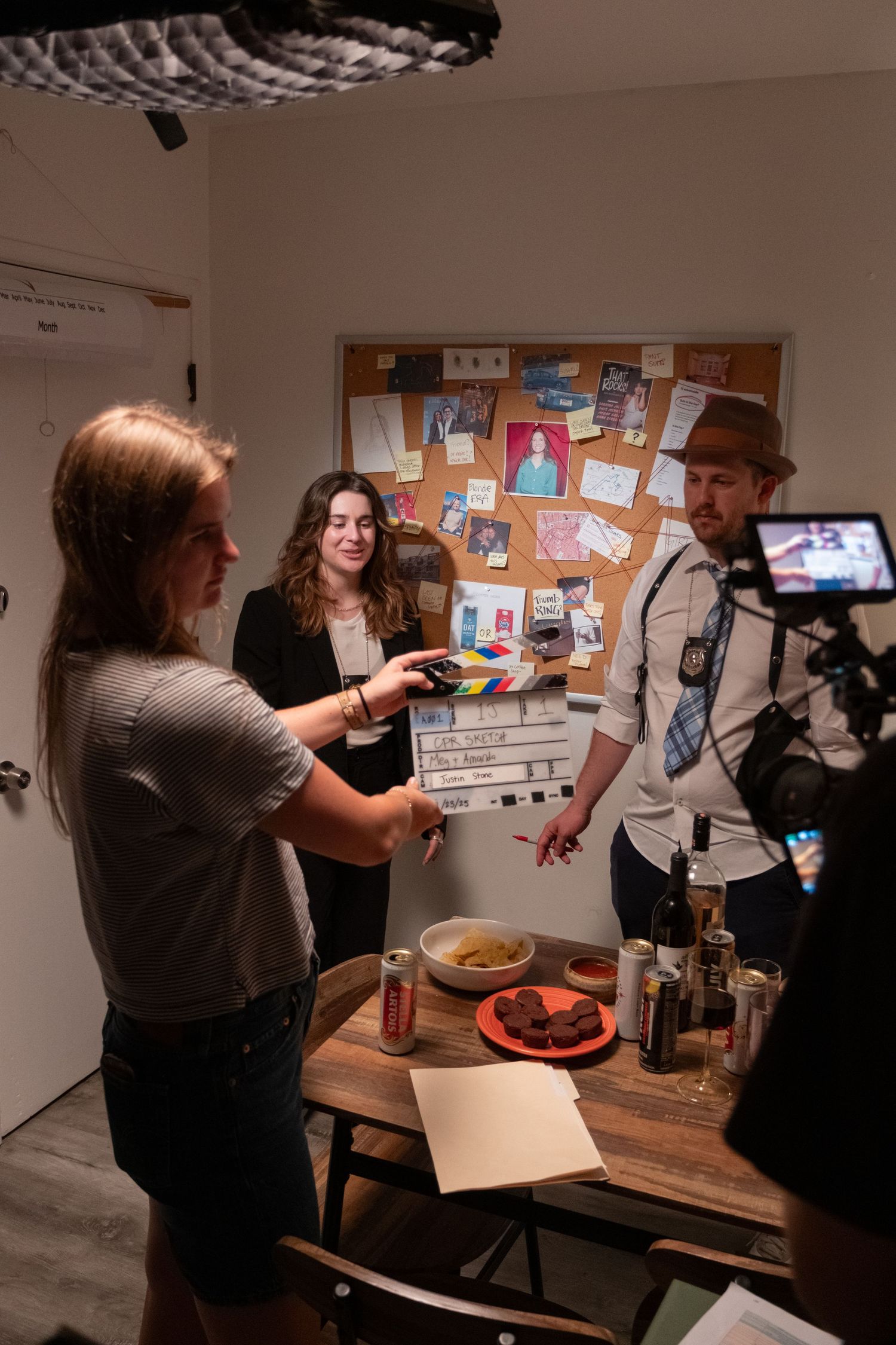 Production team reviewing content on a bulletin board in an office setting.