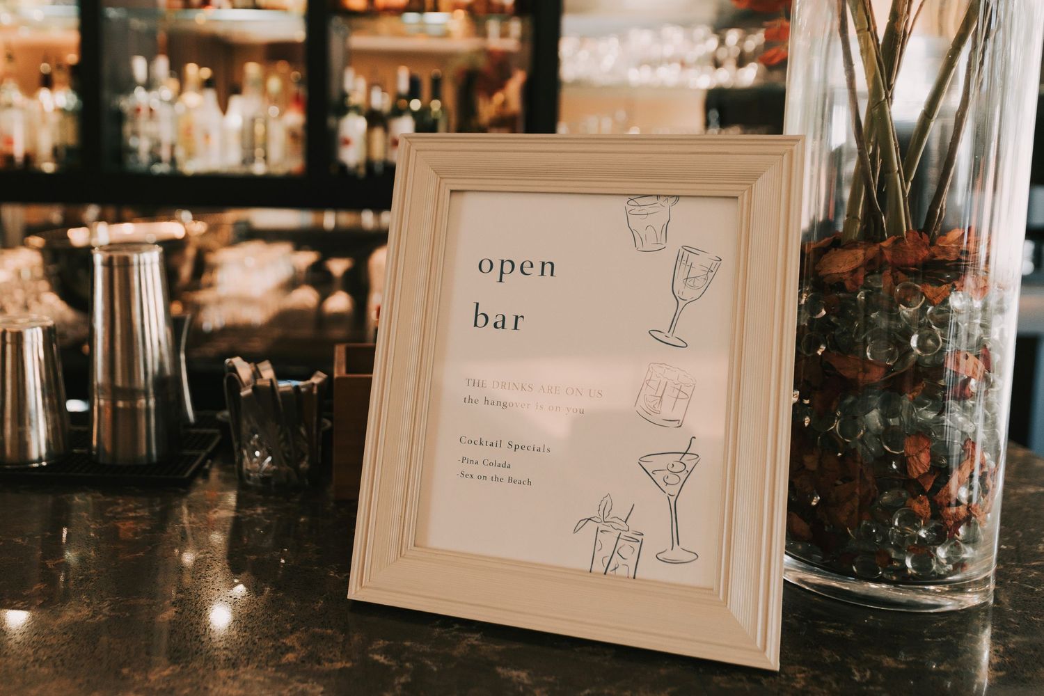 A row of elegant cocktail bar signs and menus displayed on a wall with warm ambient lighting in the background.