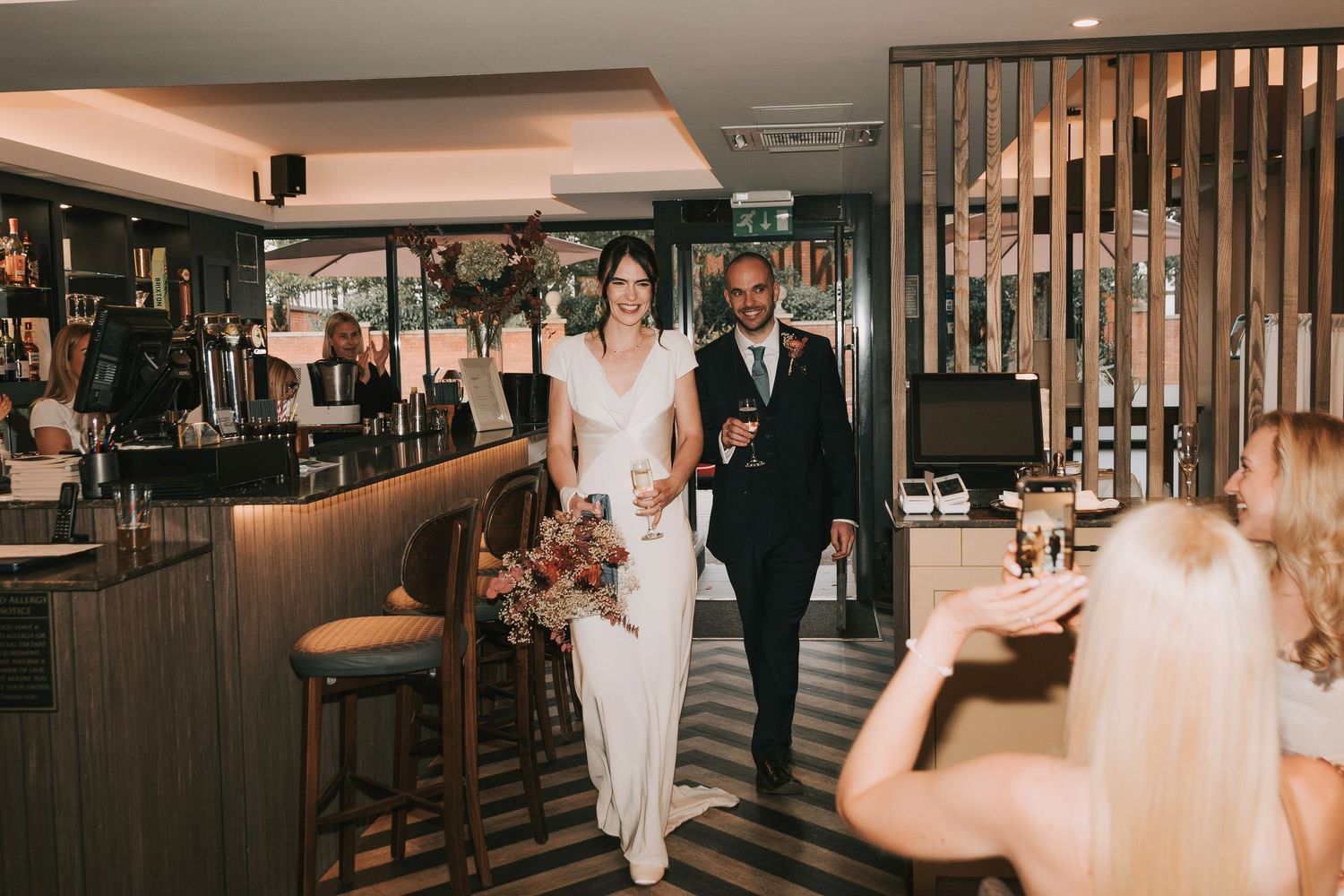 Elegant wedding celebration at a modern venue with guests mingling and dining in a sophisticated atmosphere.