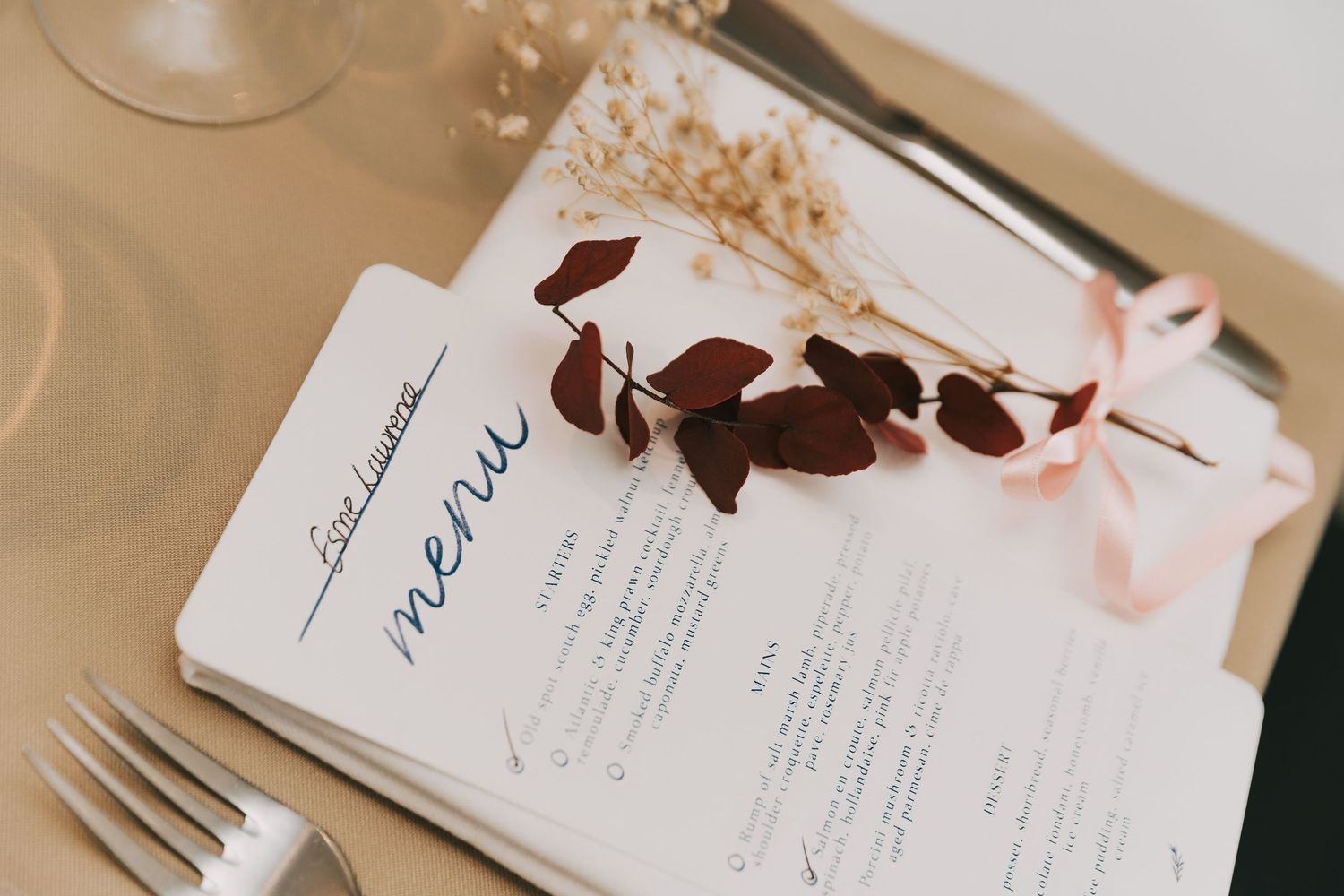 Elegant wedding invitation suite with delicate calligraphy and minimalist design elements on cream paper.