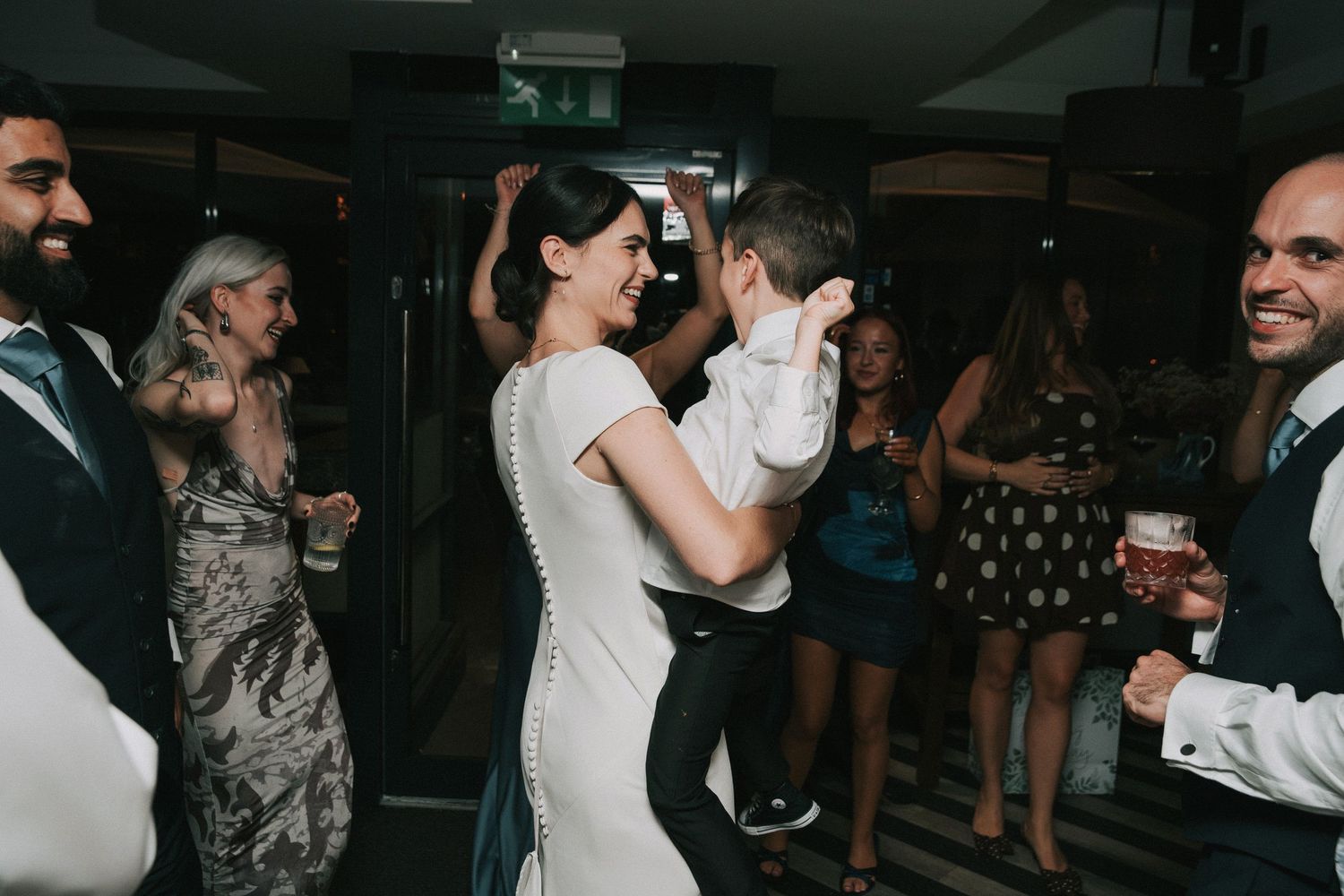 Guests enjoying themselves on a dark dance floor at an evening wedding event.