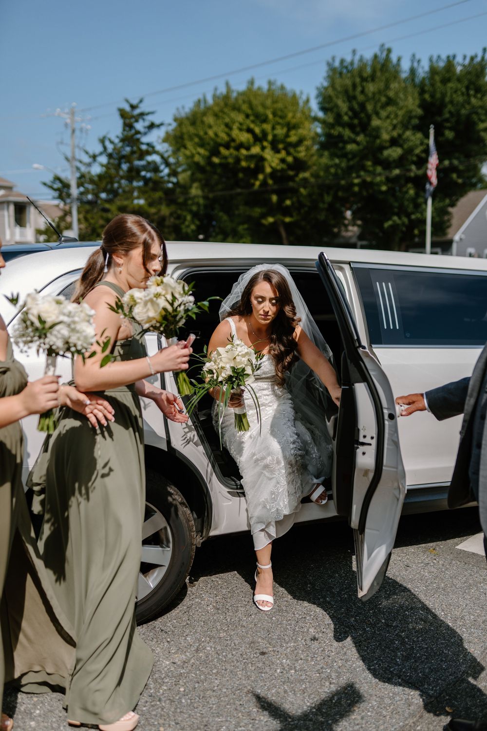 A sequence of wedding party members playfully exiting a black limousine in coordinated poses.