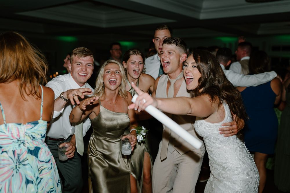 Wedding guests dancing and celebrating on a lively dance floor during the reception party.
