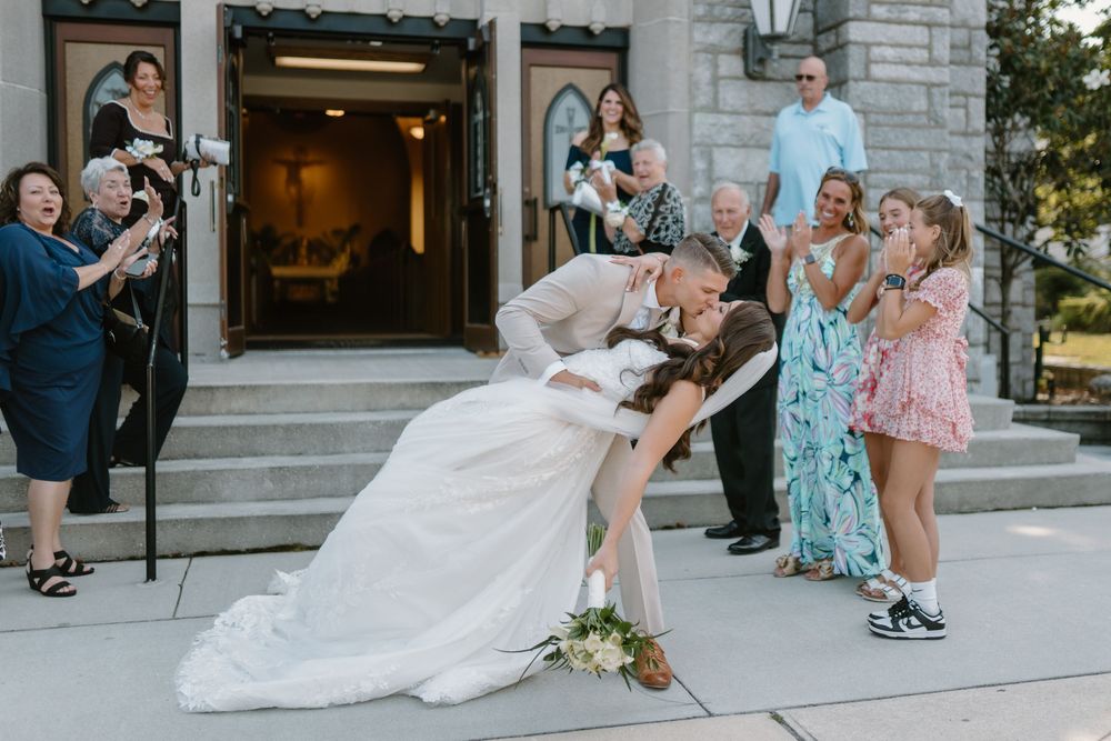 Wedding guests gather outside a stone building during the celebration.