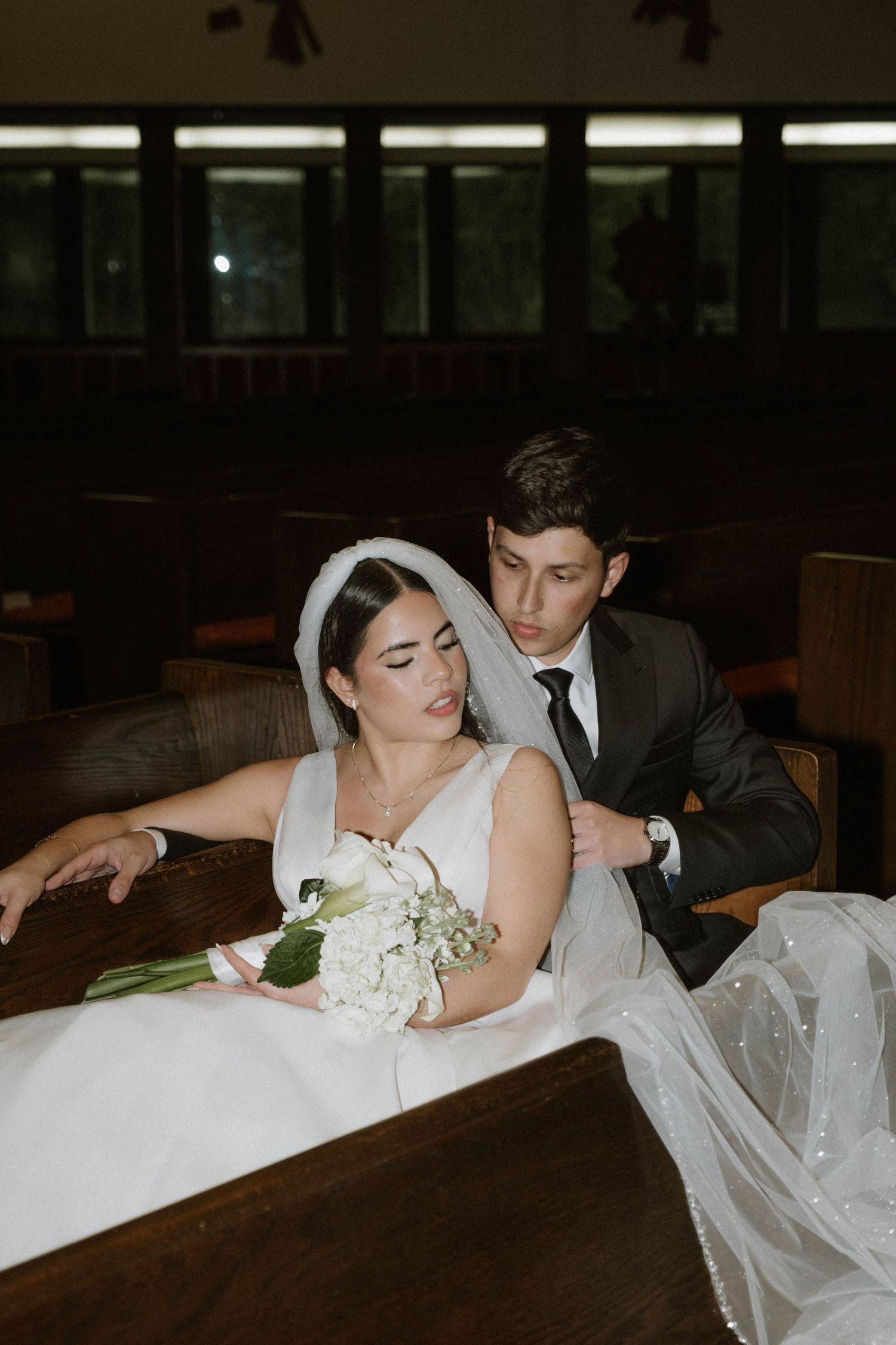 Elegant wedding details featuring white rose bouquets and formal attire.