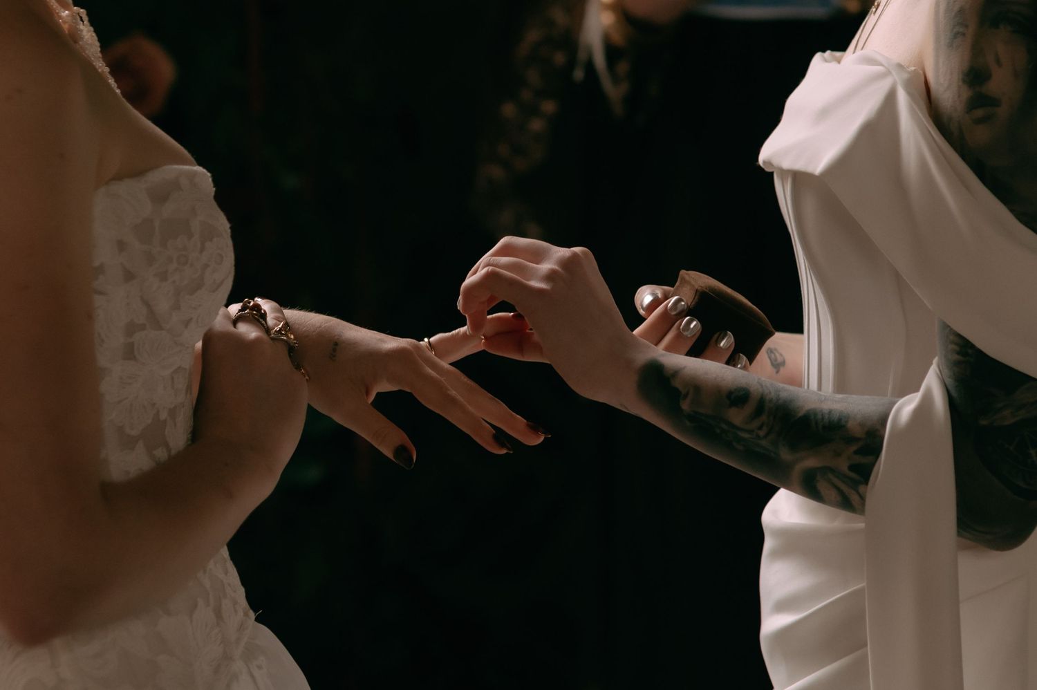 A person in a white wedding dress holds their hands out while dancing at a reception.