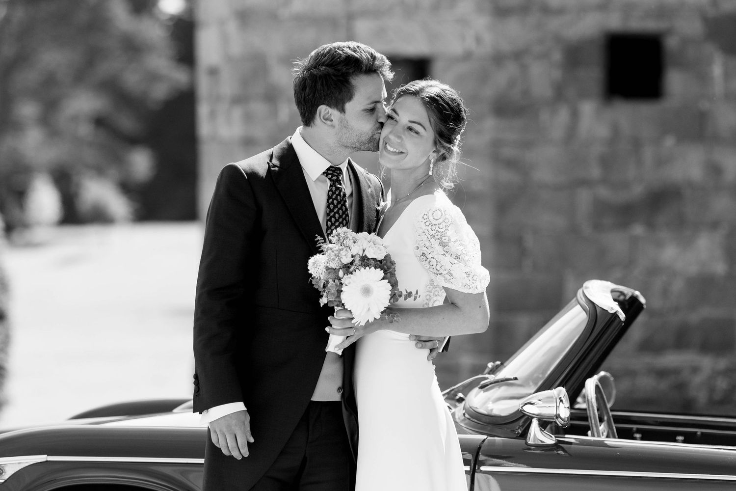 Classic black and white wedding portraits against stone architecture backdrop.