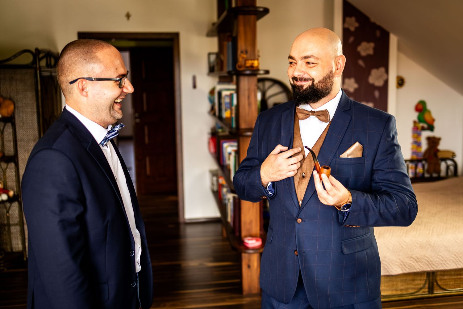 Groomsmen in navy suits sharing laughs while getting ready for the wedding.
