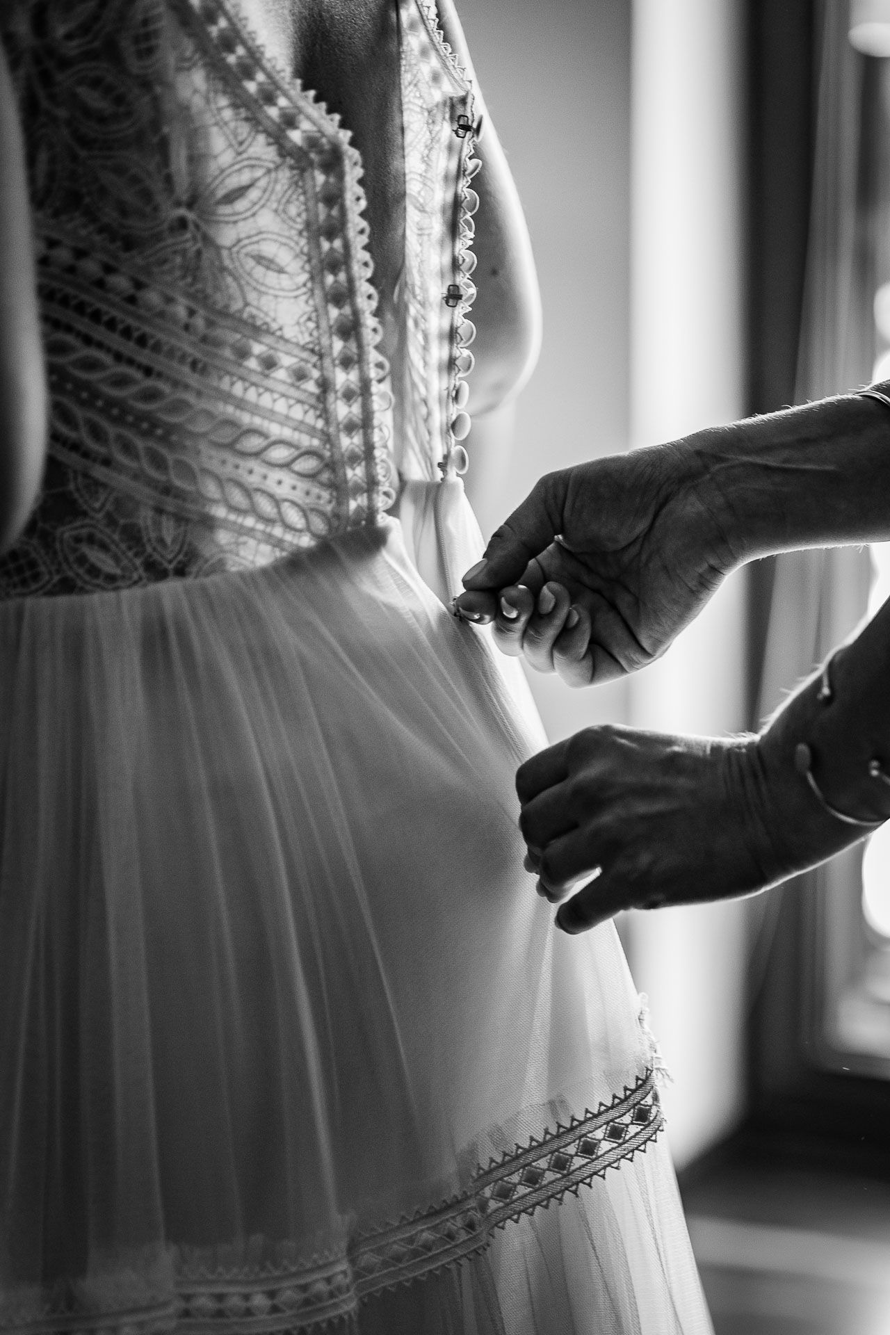 Close-up details of a white wedding dress with intricate lace and beading patterns.