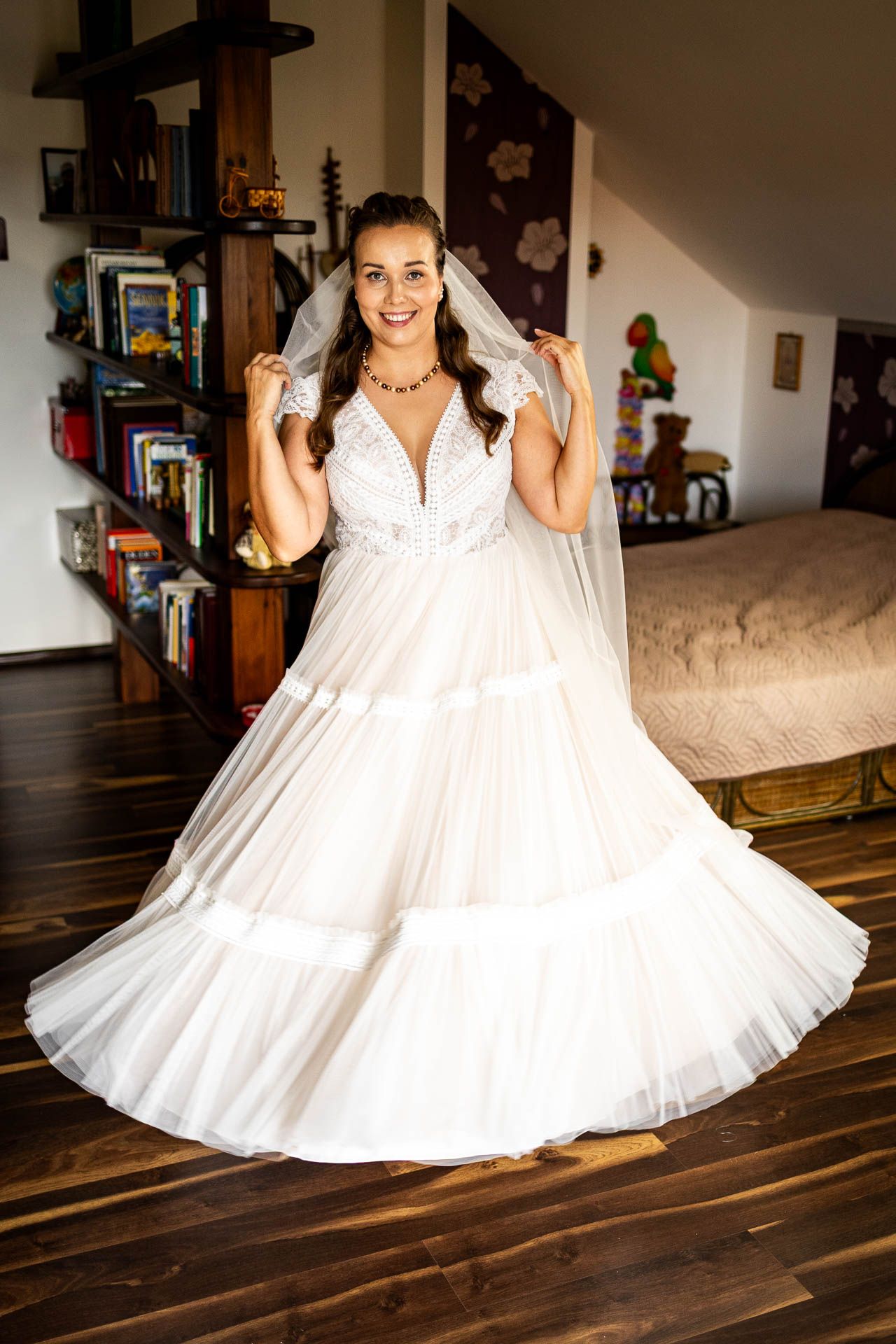 Beautiful wedding dress with flowing layers twirls in a sunlit room.