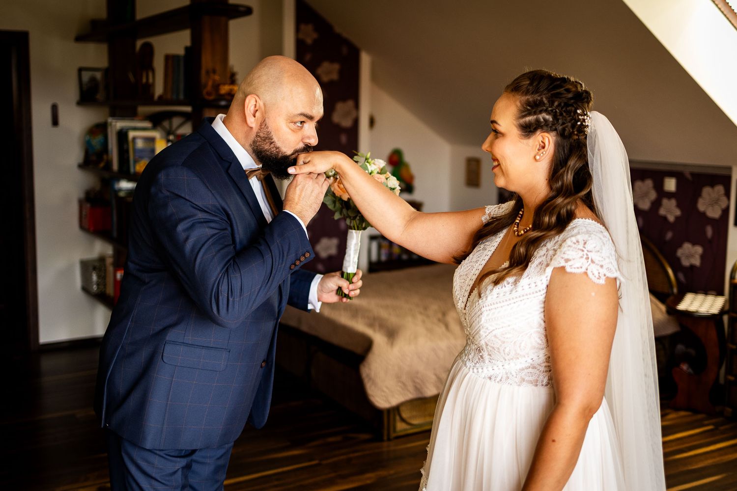 Sweet wedding moment shared between couple in navy suit and white dress.