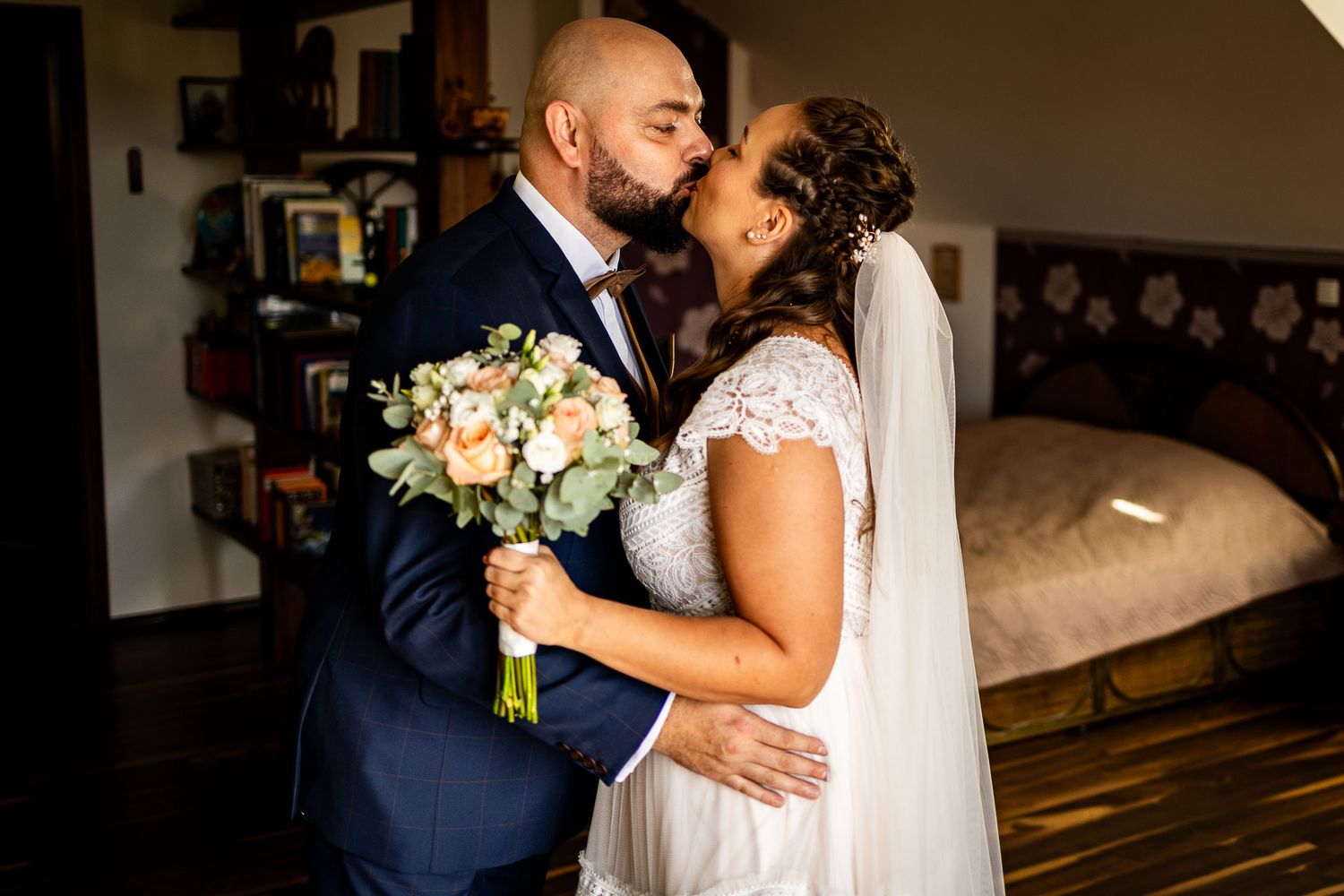 Romantic wedding moment with bouquet of cream roses and navy suit.