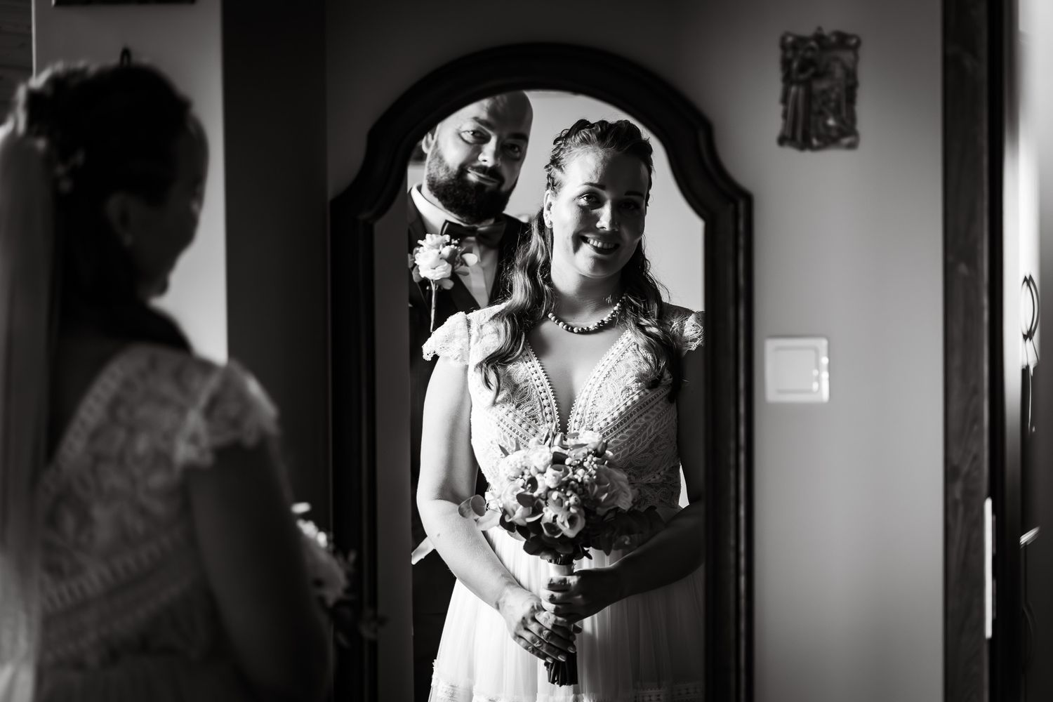 Black and white reflection of wedding preparations in vintage mirror.