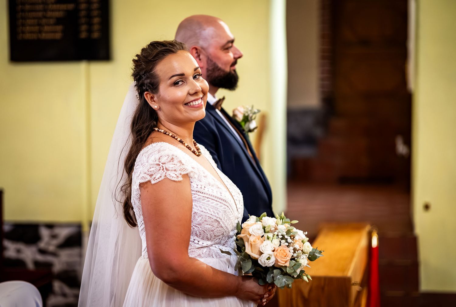 Joyful wedding ceremony moments captured in yellow-walled venue.