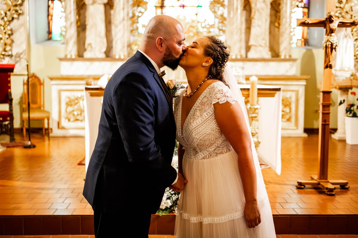 A romantic wedding ceremony unfolds in an elegantly decorated church sanctuary.