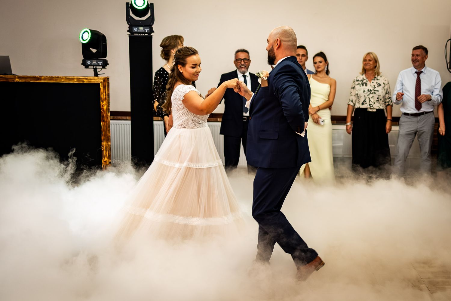Couple dancing on a misty dance floor with dramatic fog effects at their wedding reception.