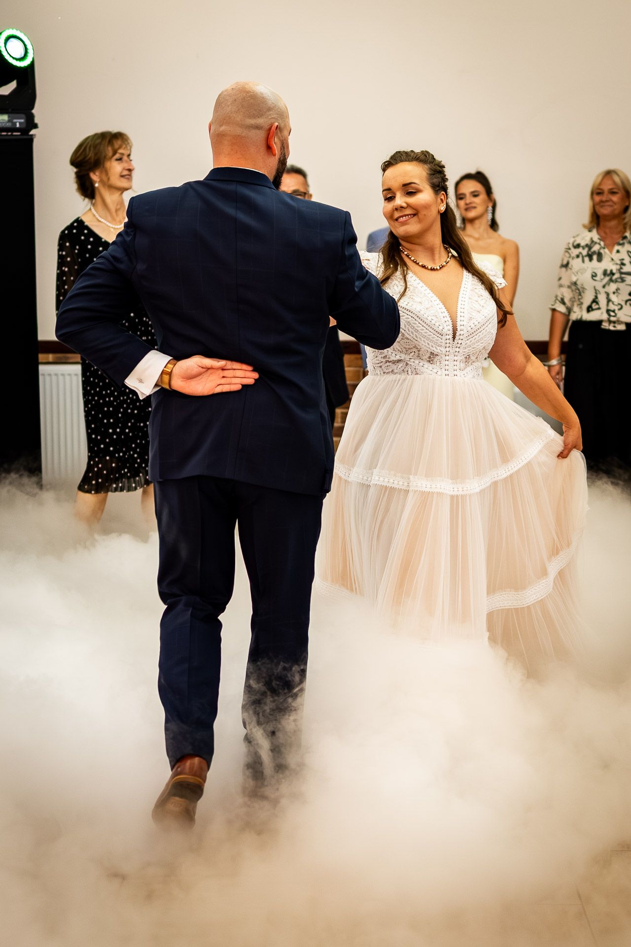 Wedding dance floor filled with ethereal fog as dancers move through the atmospheric haze.
