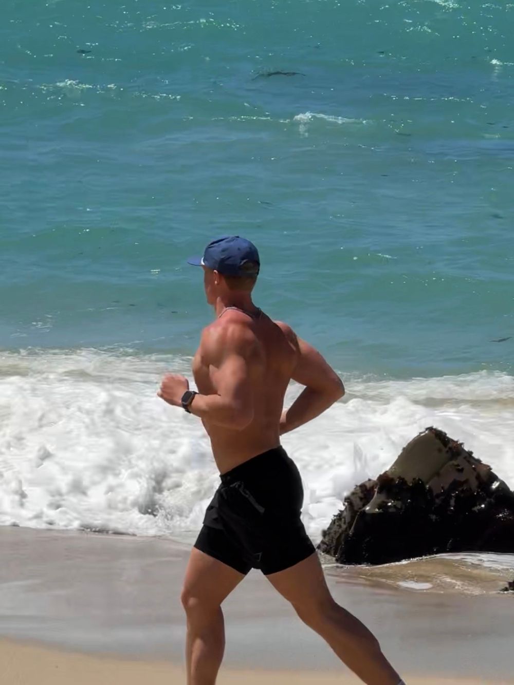 Levi Johnson running on the beach by the ocean in California