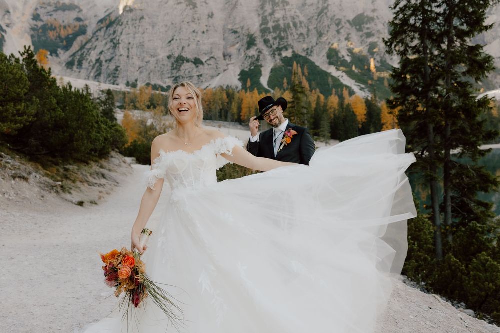 A scenic mountain wedding ceremony with snow-capped peaks and evergreen trees in the background.