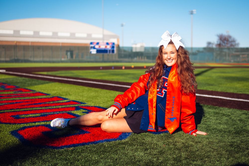 Athletic photo shoot on football field with red and blue team colors.