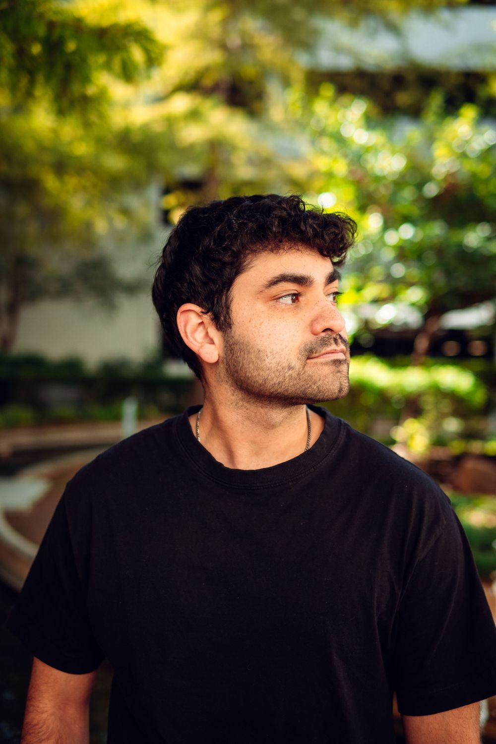Portrait sequence showing different angles of person in black shirt against blurred outdoor background.