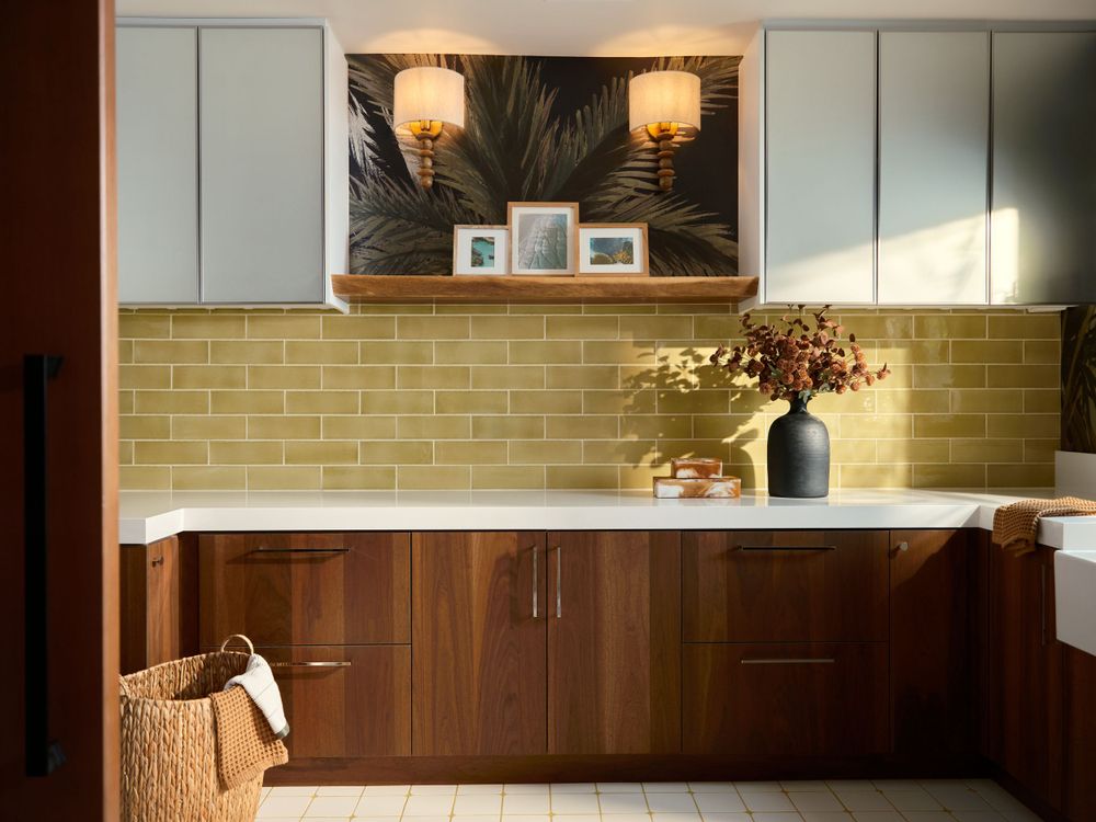 Warm modern Laundry with walnut cabinetry, olive-toned tile backsplash, and built-in shelving — interior photographed by Khoi Ly in La Jolla