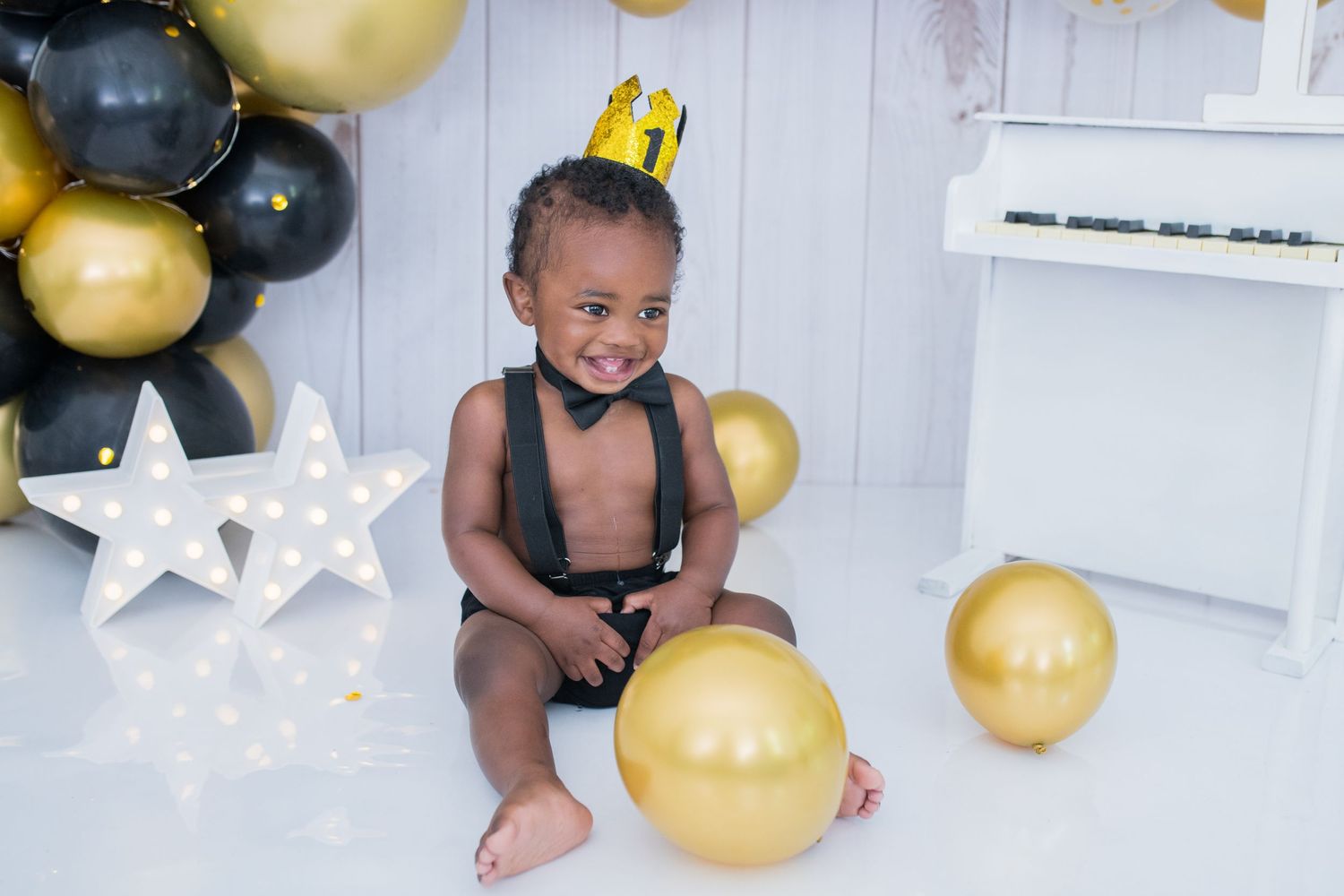 An elegant little boy in formal attire, enjoying a fun cake smash, capturing sweet and stylish moments in a beautifully set photo session!