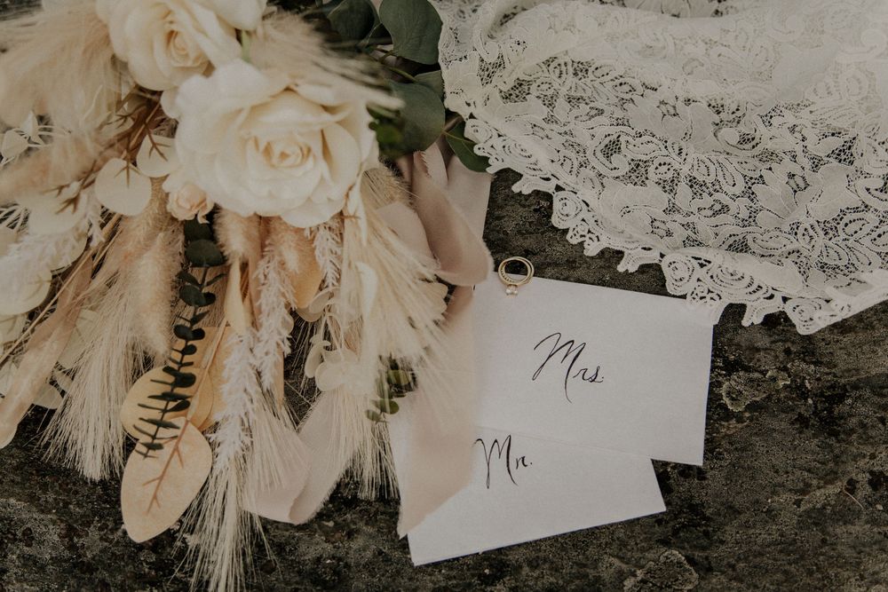 Delicate cream-colored floral arrangement with name cards in vintage style.