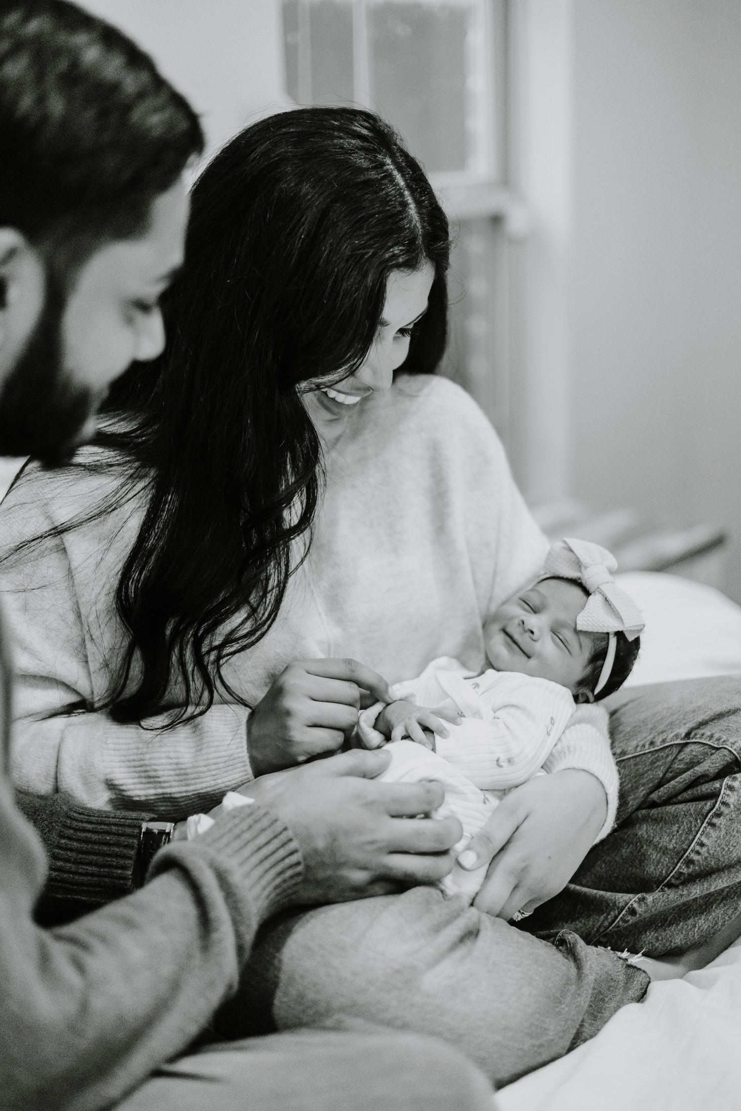 Black and white photos capture tender moments between parent and newborn.