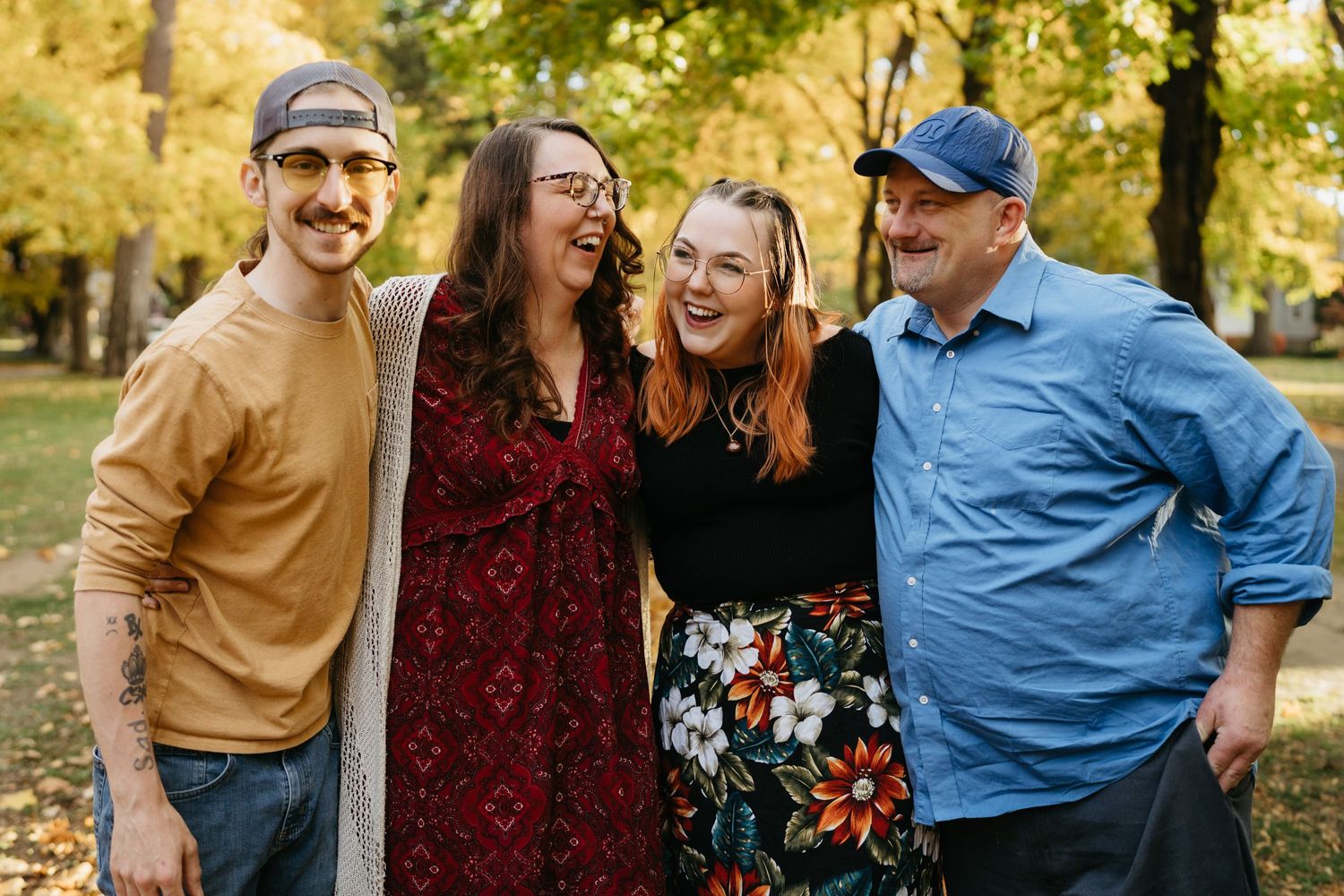 Group of friends laughing together in autumn park setting.