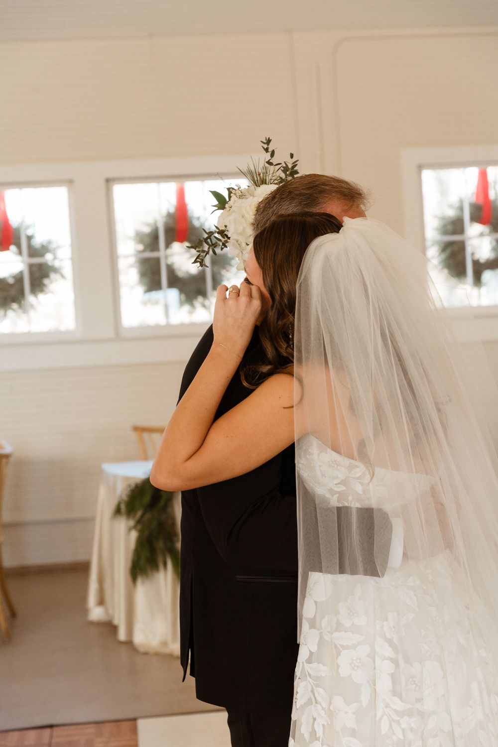 Emotional first look moment between wedding couple in a bright indoor setting.
