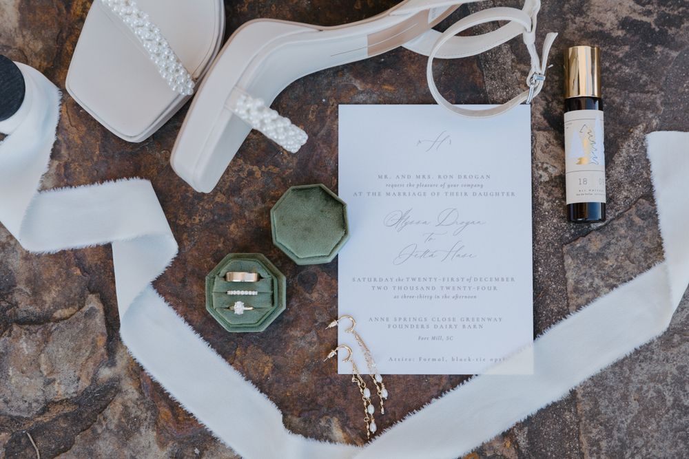 Wedding stationery and invitation suite styled on a textured dark surface.