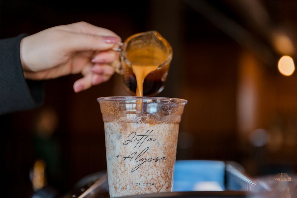 Iced coffee drinks being served in clear plastic cups at a wedding reception.