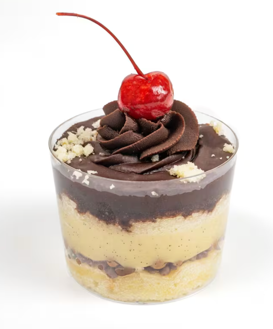 Line of chocolate cream tarts topped with raspberries, chocolate pieces and nuts on white background.
