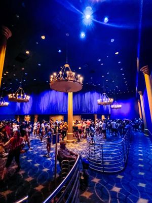 Elegant chandelier illuminates a dance floor with blue lighting and bubble effects in an ornate ballroom setting.