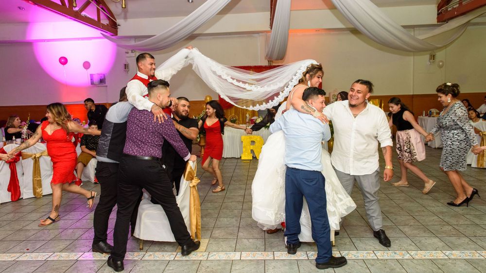 Wedding guests dance together on a decorated reception hall dance floor. Lively wedding photography in Chicago