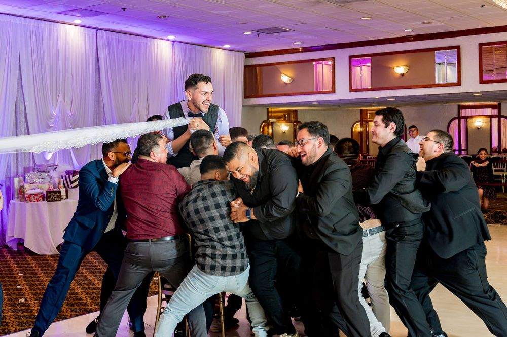 A group performs energetic dance moves at a banquet hall, photographed by Albany Capture - vibora de la mar Chicago wedding photographers.