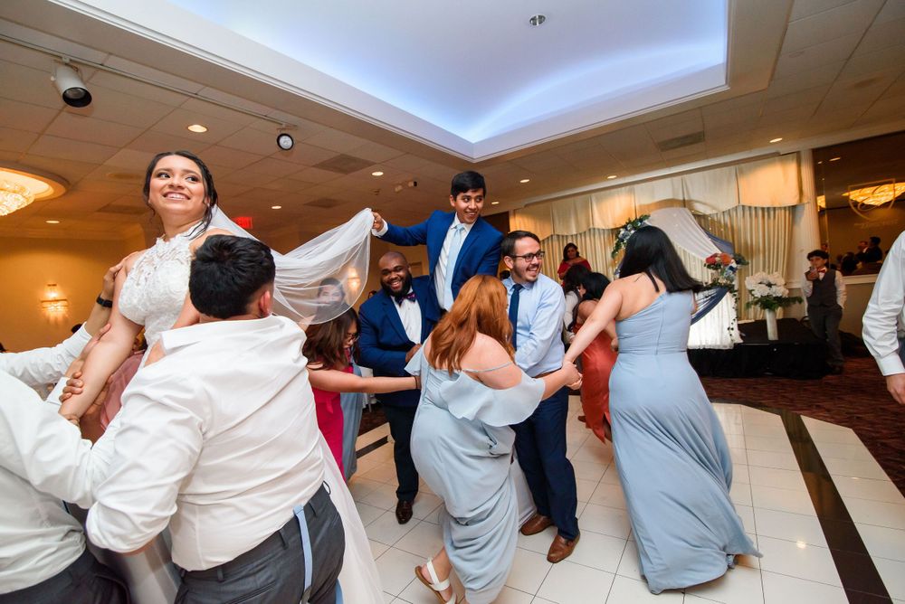 Joyful wedding guests dance and celebrate at a reception. Cultural wedding photography in Chicago