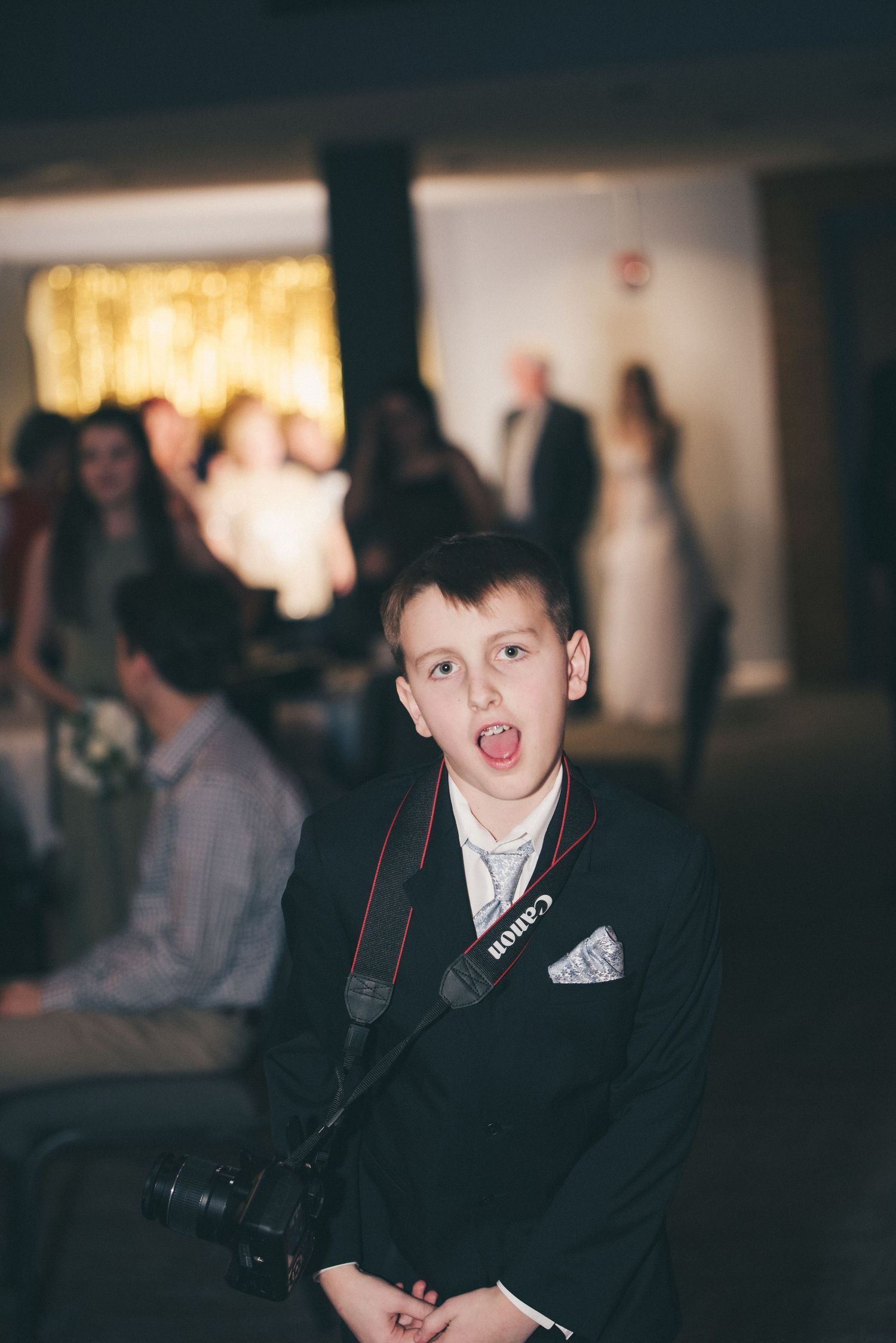 A little "second shooter" at one of my weddings! He has a canon around his neck while he poses for the camera.